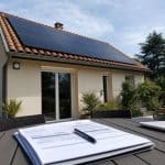 Panneaux solaires sur le toit d’une maison, avec un devis solaire au premier plan.
