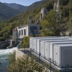 Conteneurs de batteries près d’une installation hydroélectrique dans un paysage du sud de la France