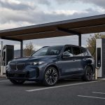 Grand SUV électrique premium stationné devant une borne rapide sur une aire européenne