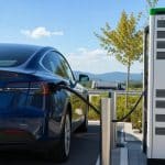 Voiture électrique en recharge rapide sur une station autoroutière en été