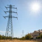 Lignes électriques sous une forte chaleur estivale près d’une zone résidentielle