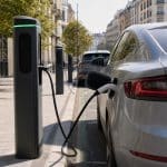 Rangee de bornes de recharge publiques en ville avec voitures branchees