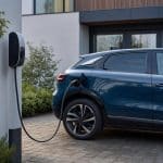 Voiture électrique compacte stationnée devant une maison moderne