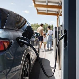 Voiture électrique branchée sur une borne rapide d'autoroute pendant un départ en vacances