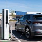 Voiture électrique en charge sur un parking de grande surface en journée