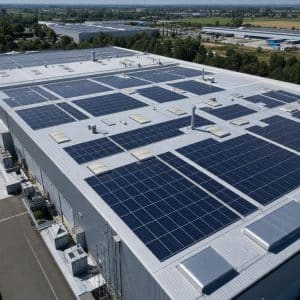 Grande toiture industrielle équipée de panneaux solaires vue en légère plongée