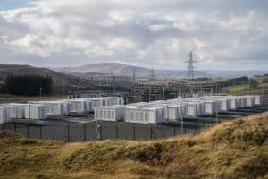 Grand site de batteries industrielles près d’infrastructures électriques sous un ciel écossais