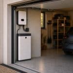 Batterie domestique blanche installée dans un garage à côté d'un onduleur solaire