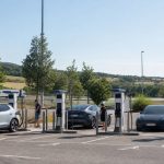 Station de recharge rapide fréquentée sur une aire française pendant les vacances d’été