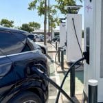 Une station de recharge rapide sur autoroute avec plusieurs voitures electriques en ete