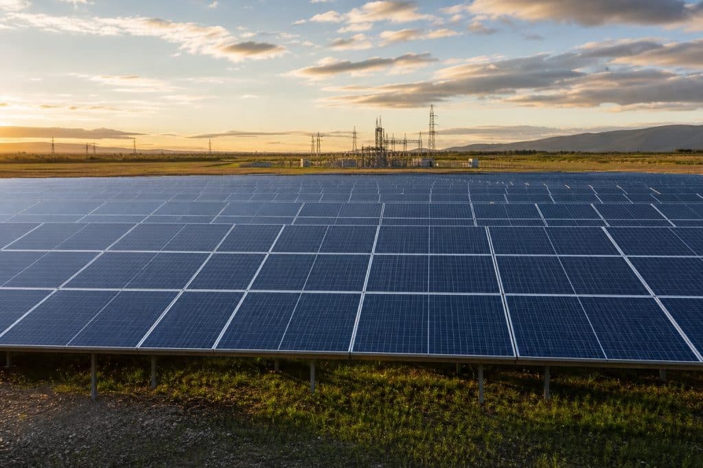 Parc solaire au sol moderne en Europe avec lignes électriques et ciel clair