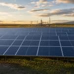 Parc solaire au sol moderne en Europe avec lignes électriques et ciel clair
