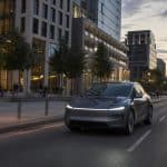Voiture électrique moderne circulant dans une grande ville européenne au crépuscule