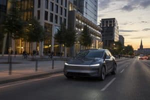 Voiture électrique moderne circulant dans une grande ville européenne au crépuscule