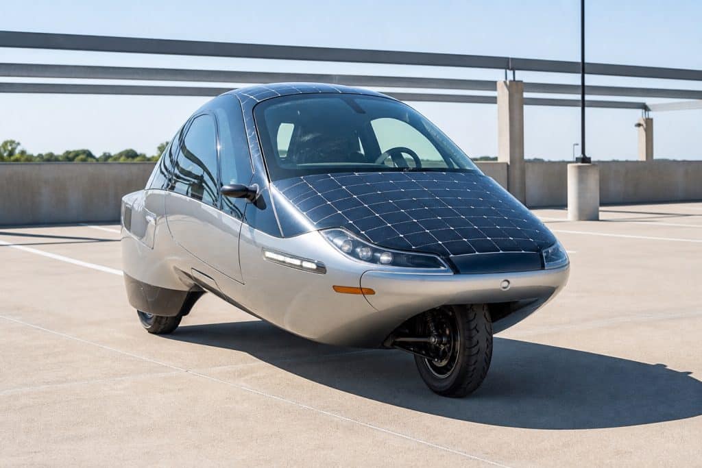 Véhicule électrique très aérodynamique stationné au soleil avec cellules solaires visibles
