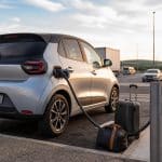 Gros plan d'un connecteur de recharge branché à une voiture électrique
