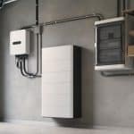 Batterie domestique murale installée dans un garage moderne à côté d'un onduleur solaire