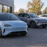 Illustration d'un parc de voitures électriques neuves devant un showroom automobile