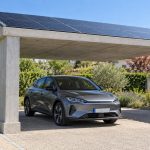 Ombrière photovoltaïque en béton installée sur une allée de maison et abritant une voiture
