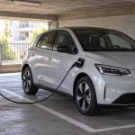 Parking d'immeuble avec une voiture électrique et une borne de recharge individuelle